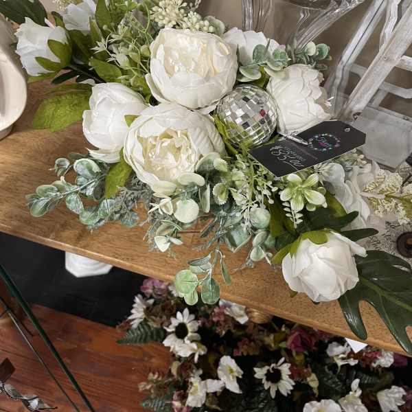 White floral arrangement with peony-like blooms in a clear vase