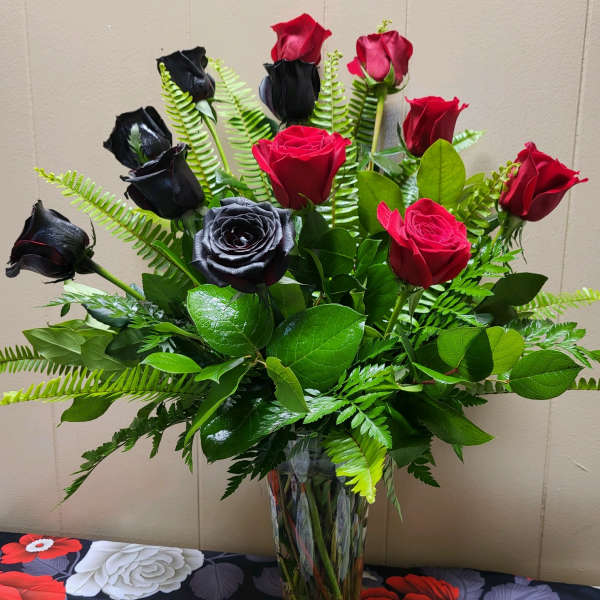 Bouquet of red and black roses in a clear glass vase