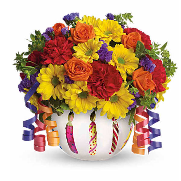 Colorful bouquet of roses, daisies, and carnations in a white vase with curling ribbons