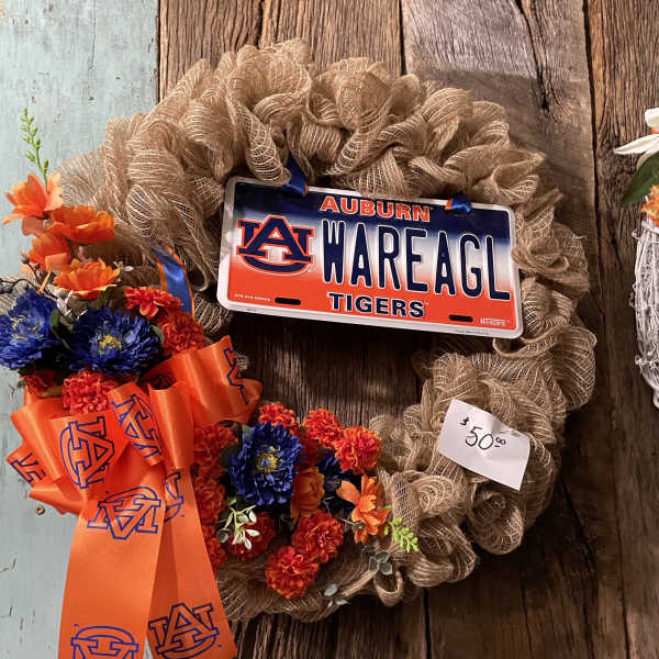 A floral wreath with an Auburn license plate and orange ribbon