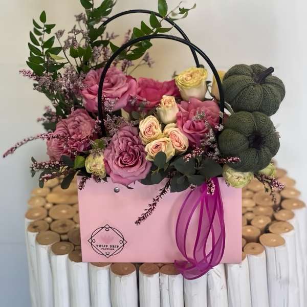 Pink and cream roses in a pink gift box with a ribbon