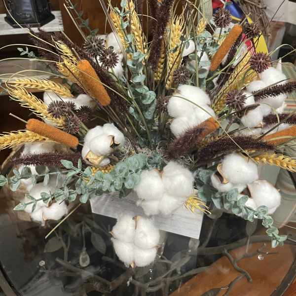 Arrangement of cotton bolls, wheat, and dried grasses in a container