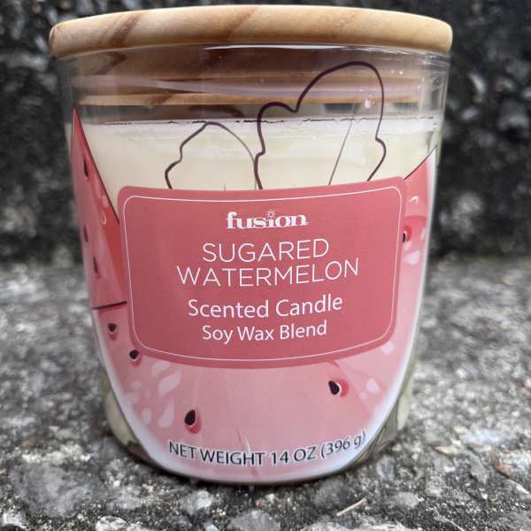 A sugared watermelon scented candle in a glass jar with a wooden lid