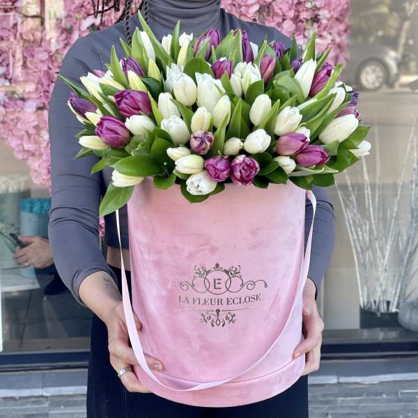 Bouquet of white and purple tulips in a pink gift box