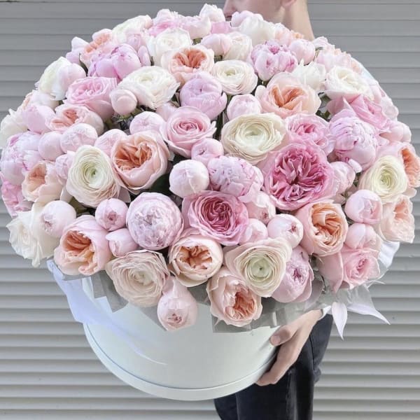 Large pastel bouquet of pink and white flowers in a round white box