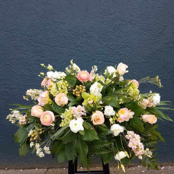 Large pastel floral arrangement with roses and white blooms