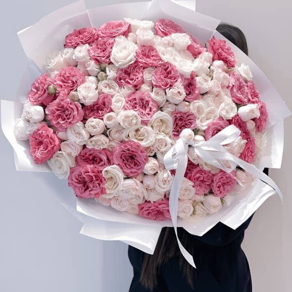 Large bouquet of pink and white roses wrapped in white paper