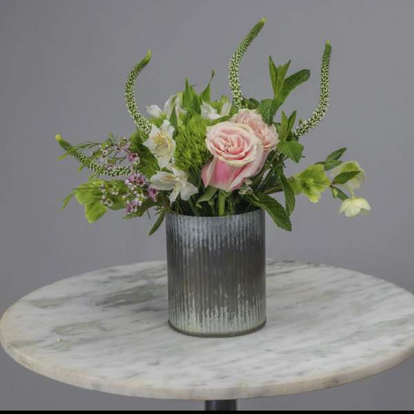 Pink roses and white flowers in a ribbed metal vase