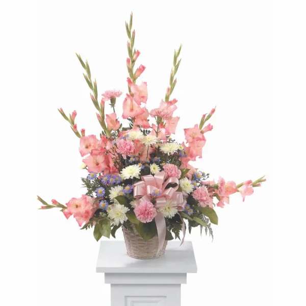 Pink and white mixed flower arrangement in a basket with a ribbon