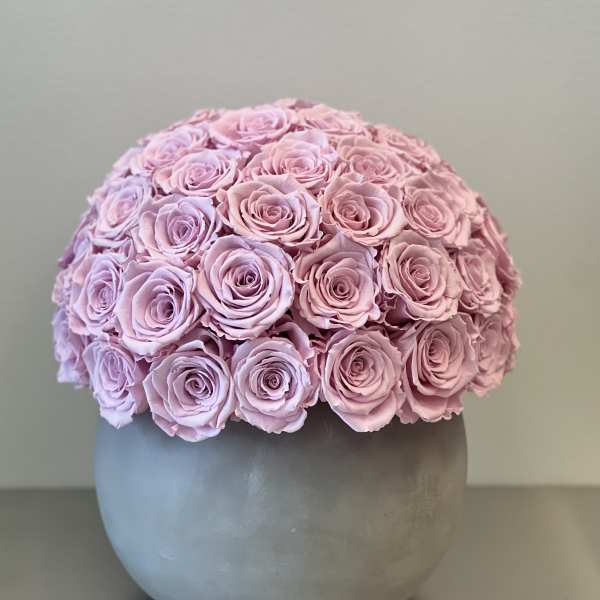 Round bouquet of pale pink roses in a gray vase