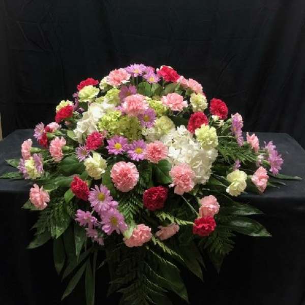 Large floral spray with pink, white, and red carnations and daisies