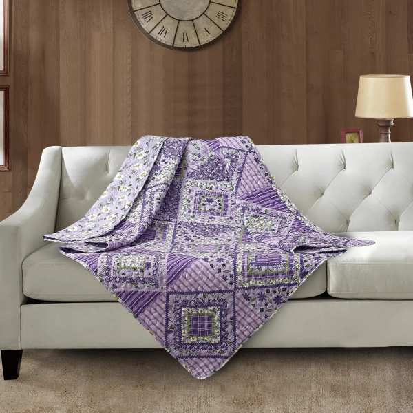 Purple patchwork quilt draped over a white sofa