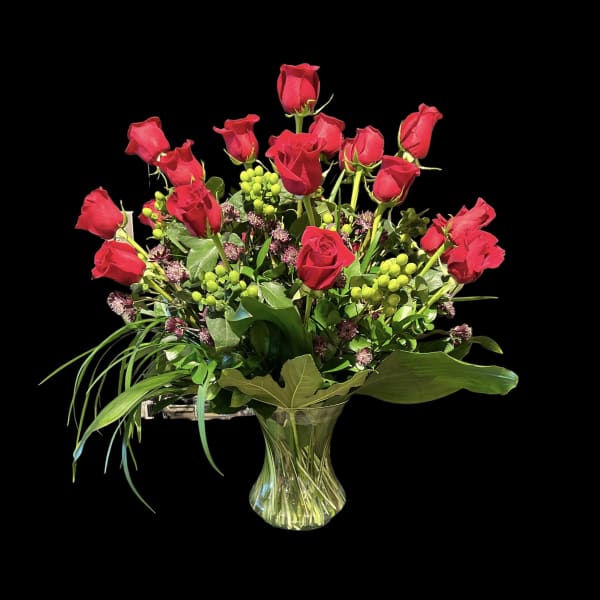 Red roses arranged in a clear glass vase