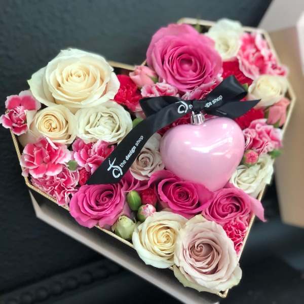 Heart-shaped box of pink and white roses with a pink ornament