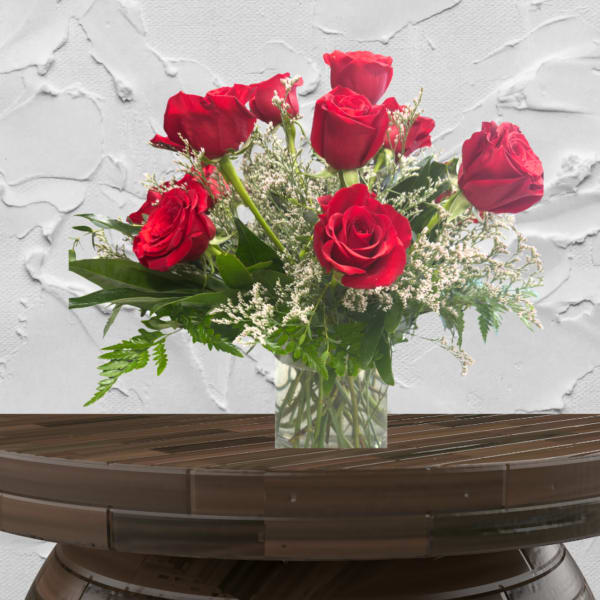 Red roses arranged in a clear glass vase