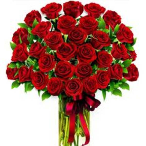 Bouquet of red roses in a clear glass vase with a red ribbon