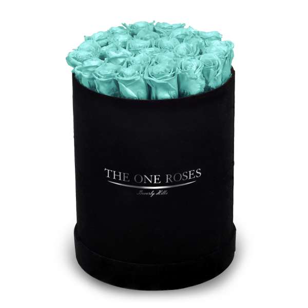 Turquoise roses arranged in a black round box
