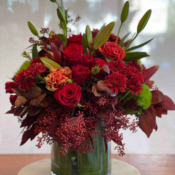 Red roses and chrysanthemums arranged in a glass vase