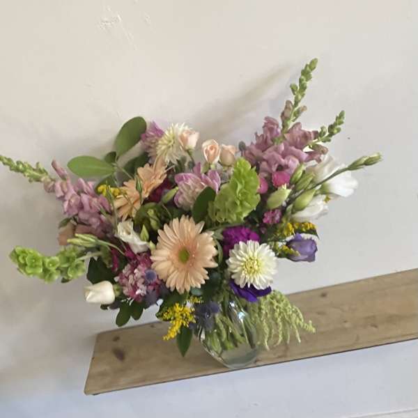 Mixed bouquet in a clear glass vase with pink, white, and purple flowers