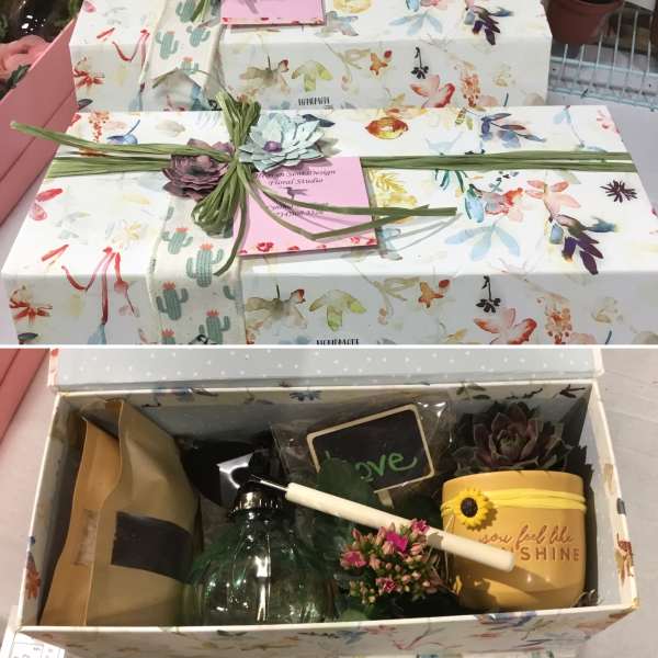 Gift box with a floral lid, ribbon, and small succulent accents