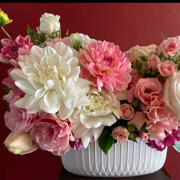 Pink and white floral arrangement in a white ribbed vase