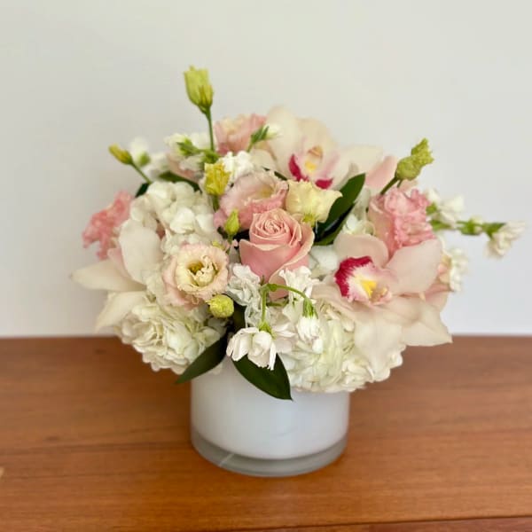 Pink and white floral arrangement in a white vase
