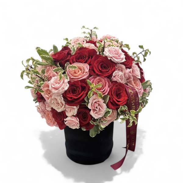 Bouquet of red and pink roses in a black hatbox