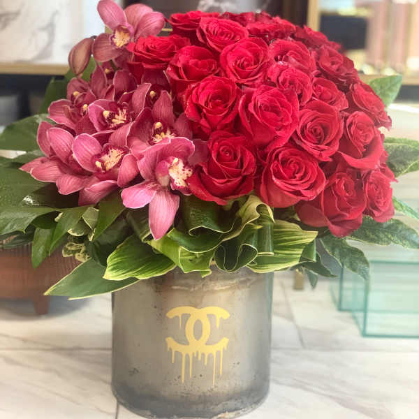 Red roses and pink orchids in a gray vase