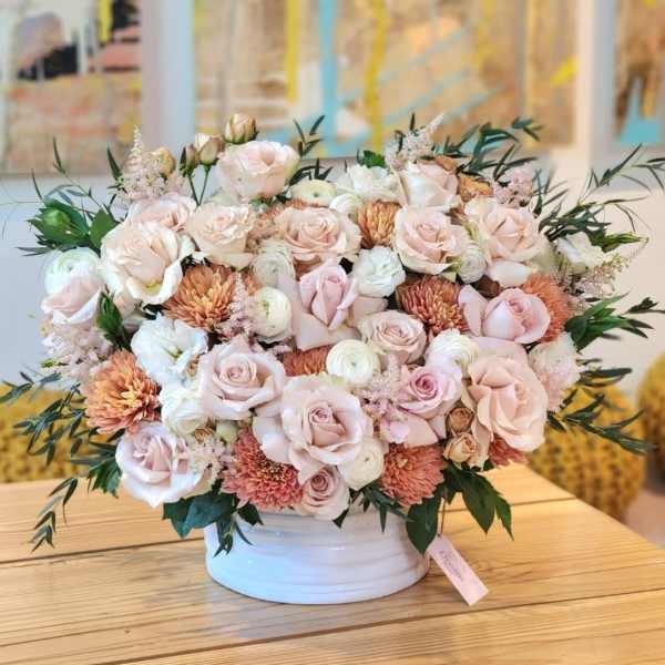 Blush rose and chrysanthemum arrangement in a white vase