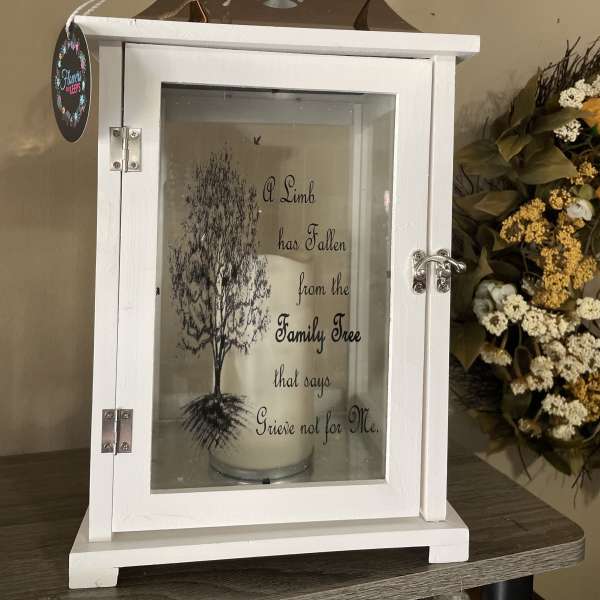 White memorial lantern with a candle and floral accents