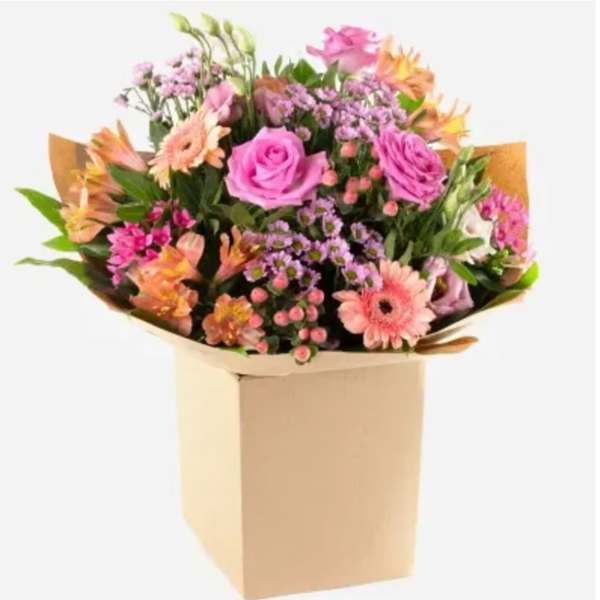 Mixed pink and peach flower bouquet in a tan box