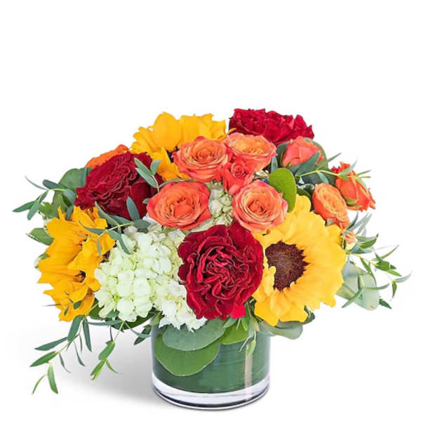 Bouquet of red and orange roses with yellow sunflowers in a glass vase