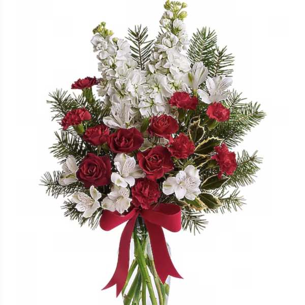 Red and white floral bouquet in a clear glass vase with a red ribbon