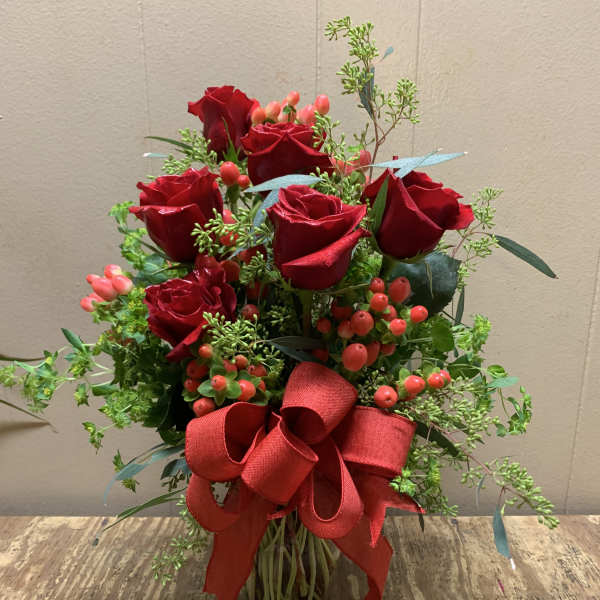 Red roses in a glass vase with a large red ribbon