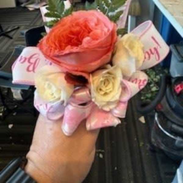 Small bouquet of pink and cream roses with ribbon wrap