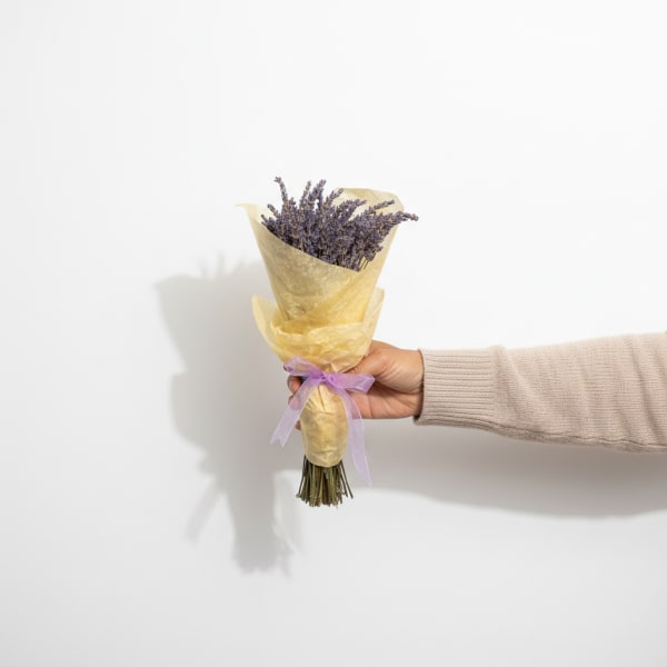 Small lavender bouquet wrapped in yellow paper with a purple ribbon