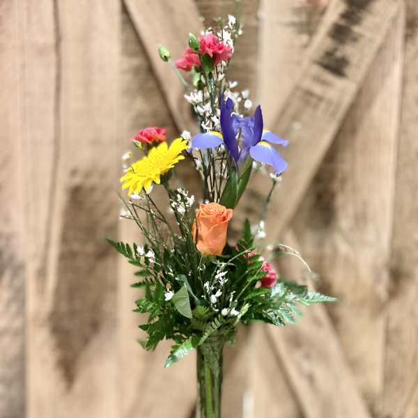 Mixed bouquet of colorful flowers in a clear glass vase