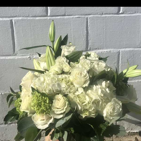 White roses and lilies arranged in a low bouquet