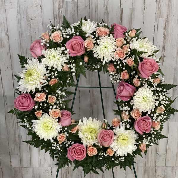 Pink and white floral wreath on a stand