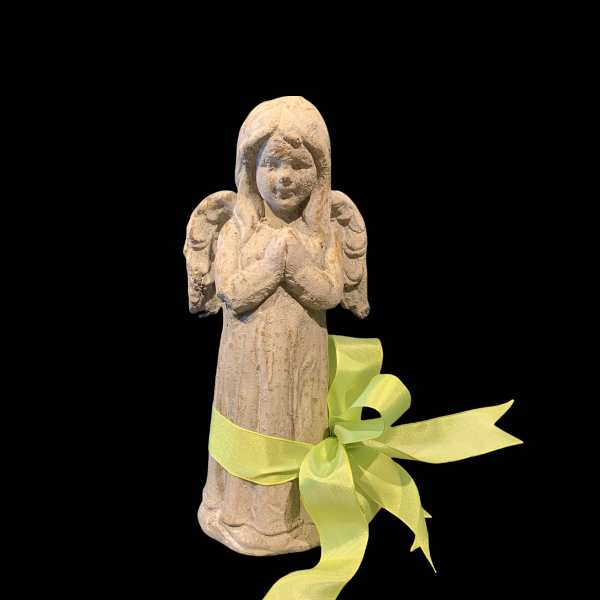 Small angel figurine tied with a yellow ribbon on a black background