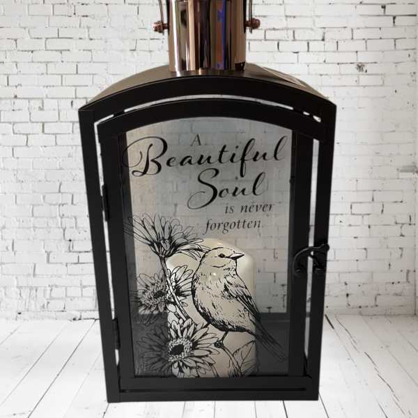 Black lantern with a memorial quote and bird illustration