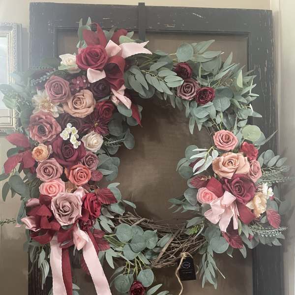 Heart-shaped floral wreath with pink and burgundy roses and eucalyptus