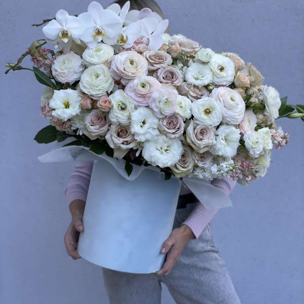 Large bouquet of white orchids and pale roses in a white box