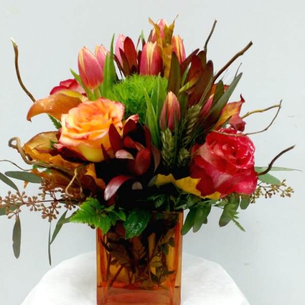 Mixed bouquet of roses and tulips in an amber glass vase