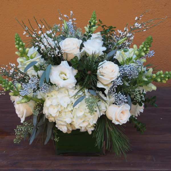 White roses and hydrangeas in a square vase with silver accents