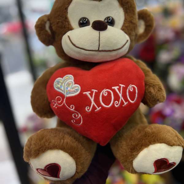 Plush monkey holding a red heart with "XOXO" embroidery
