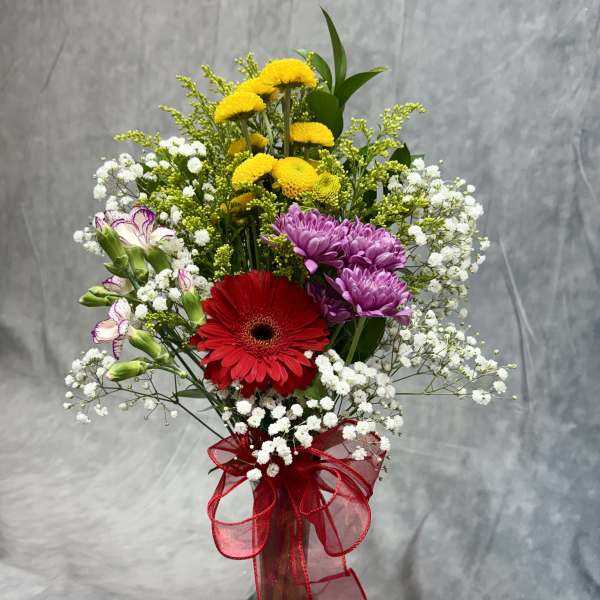 Mixed bouquet in a glass vase with red, purple, and yellow flowers