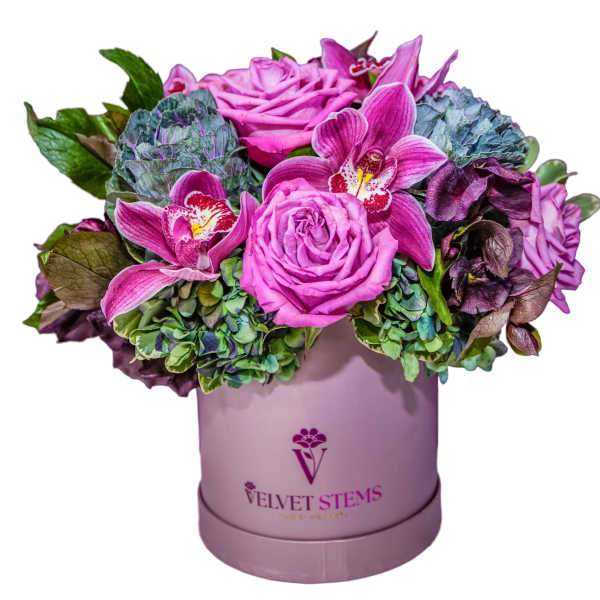 Pink roses and orchids arranged in a lavender hat box