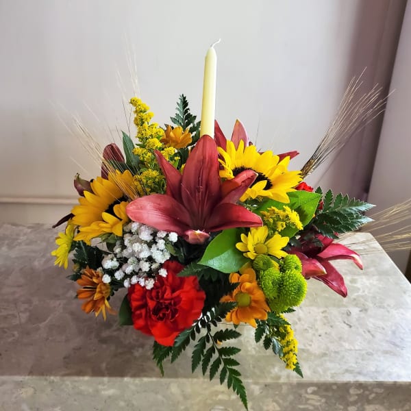 Colorful floral centerpiece with a tall candle in the middle