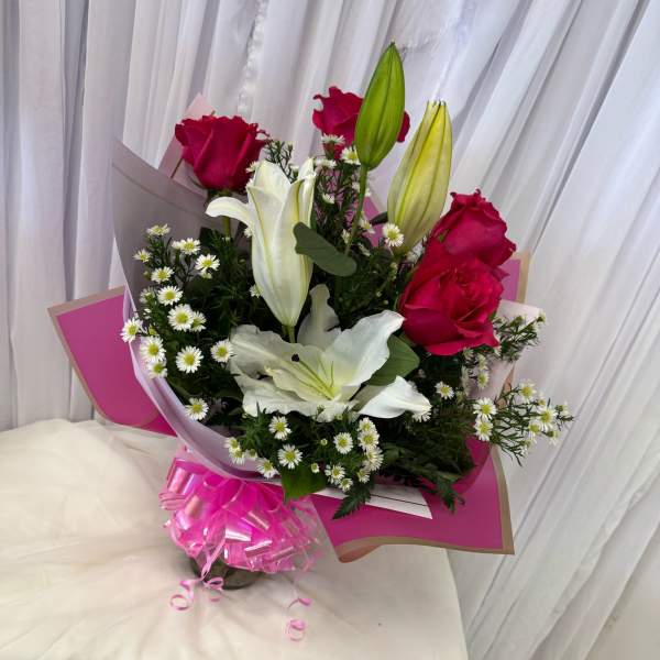 Bouquet of pink roses and white lilies with small white daisies